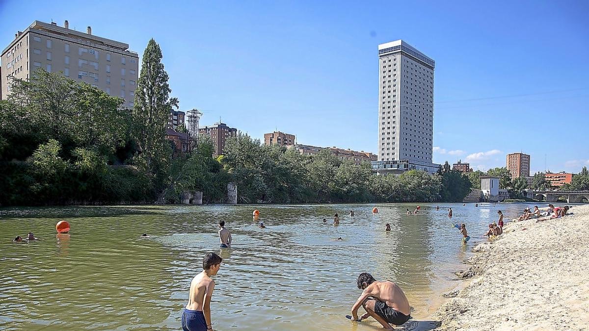 Bañistas disfrutan del agua en la playa de Las Moreras. E. M.