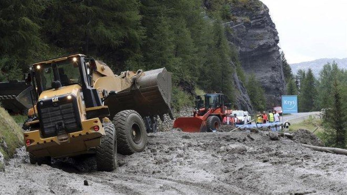 Excavadoras tratan de limpiar la carretera para el paso del Tour de Francia.-AP / / THIBAULT CAMUS