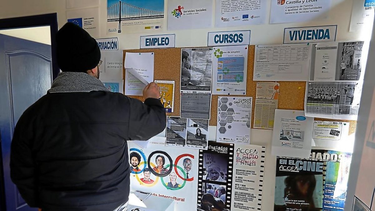 Un refugiado consulta el tablón de anuncios de Accem.- J. M. LOSTAU