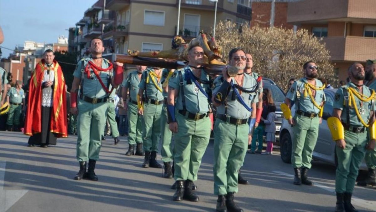 Exlegionarios llevan al Cristo de la buena muerte por las calles de L'Hospitalet durante la procesión del 2015, junto con el sacerdote Custodio Ballester (al fondo, a la izquierda).-PARROQUIA DE LA IMMACULADA CONCEPCIÓN