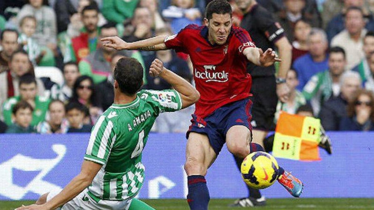 El defensa del Betis Antonio Amaya (i) y el centrocampista del Osasuna Álvaro Cejudo luchan por el balón, durante el partido disputado el 12 de enero del 2014.-Foto: EFE / JOSÉ MANUEL VIDAL