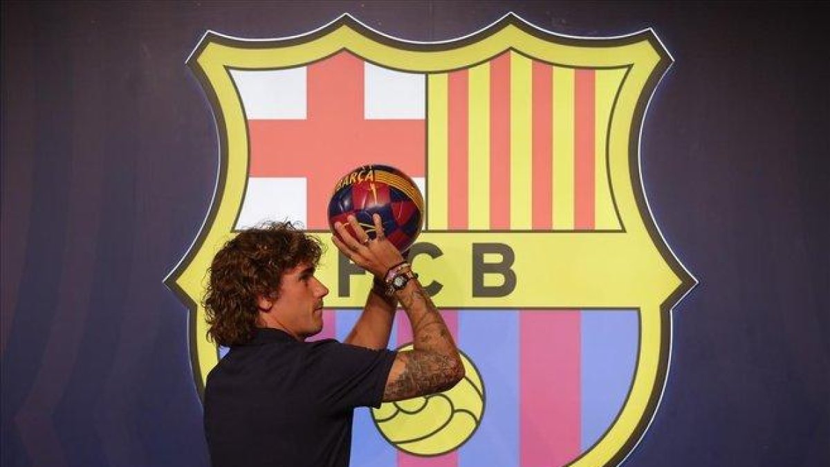Griezmann simula tirar a canasta tras el posado en la tienda del Barça junto al Camp Nou.-