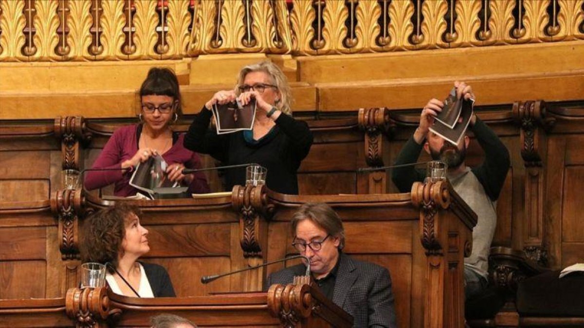 Los concejales de la CUP en el Ayuntamiento de Barcelona, Maria Rovira, María José Lecha y Josep Garganté, rompen fotos del Rey durante un pleno municipal.-ACN