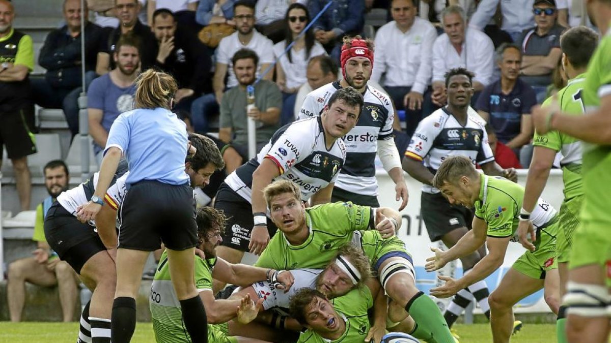 Michael Walker-Fitton es aplastado por dos jugadores rivales en una acción del partido.-PHOTOGENIC
