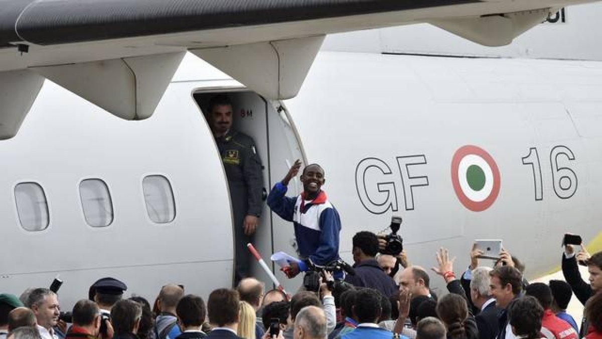 Los 19 refugiados eritreos suben al avión que ha de llevarles a Suecia.-AFP / ANDREAS SOLARO