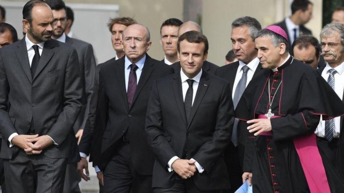 Macron (centro) conversa con el arzobispo de Rouen, Dominique Lebrun (derecha), durante la ceremonia por la muerte, hace un año, del sacerdote Jacques Hamel, degollado por dos yihadistas.-EFE / JULIEN DE ROSA