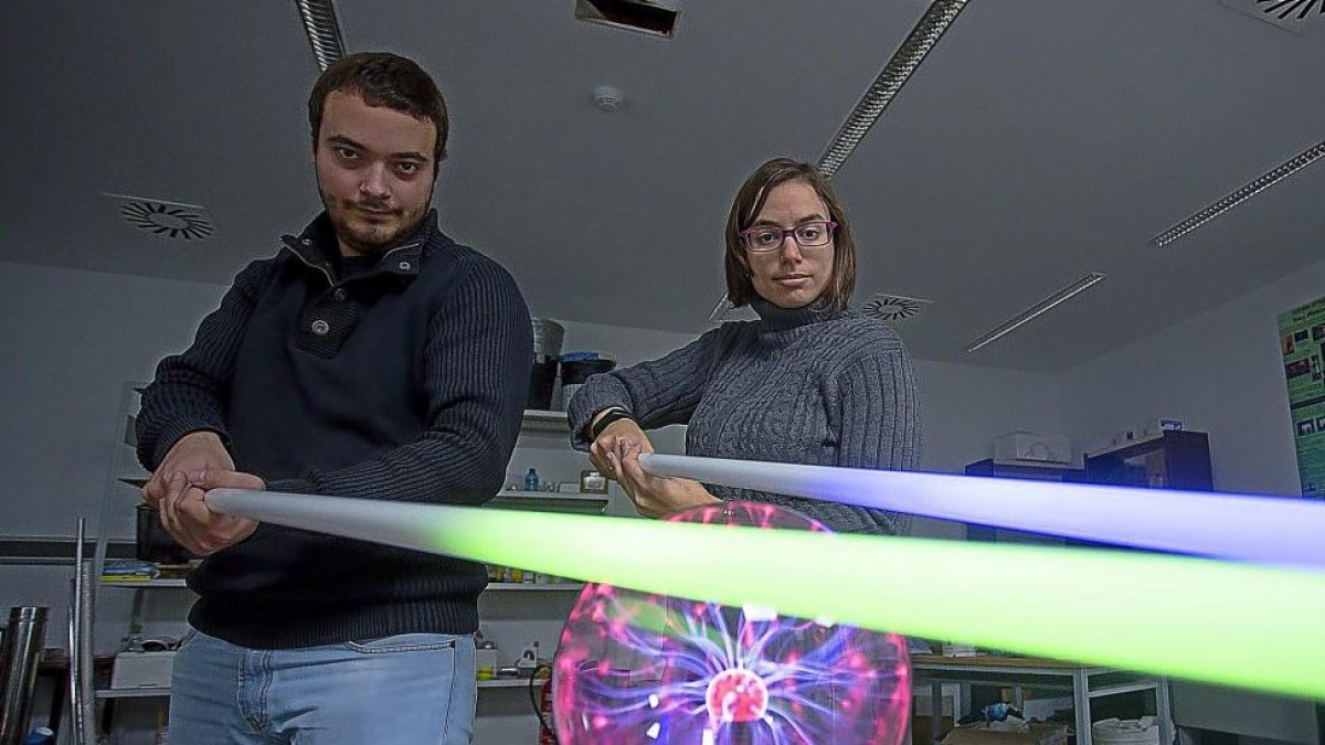 Los doctorandos en Física Luis Sánchez-Tejerina y Verónica González iluminan los fluorescentes con una bola de plasma simulando una espada láser.-T. SANCHO