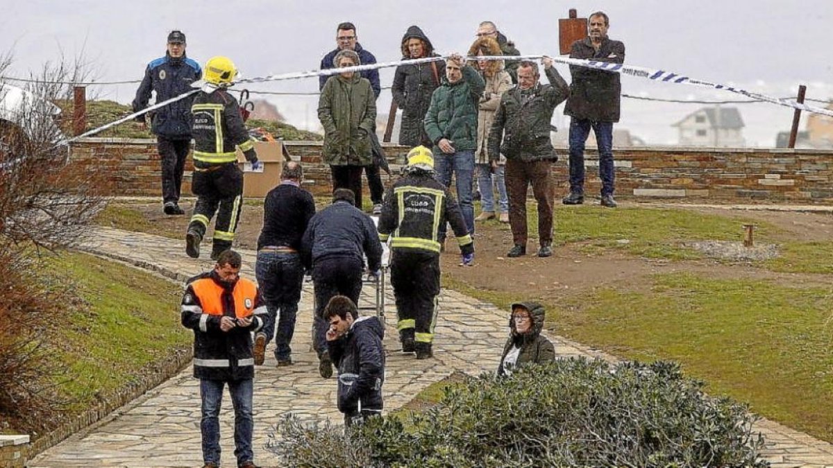 Momento en el que los servicios funerarios, policiales y de Bomberos retiran el cuerpo de la paya de Ribadeo.-EL PROGRESO