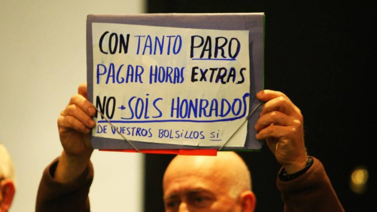 Un asistente al pleno del Ayuntamiento de Ponferrada, muestra una pancarta en contra de la aprobación del punto del orden del día para el pago de las horas extras realizadas por la policía municipal de Ponferrada en el Mundial de Ciclismo-Ical