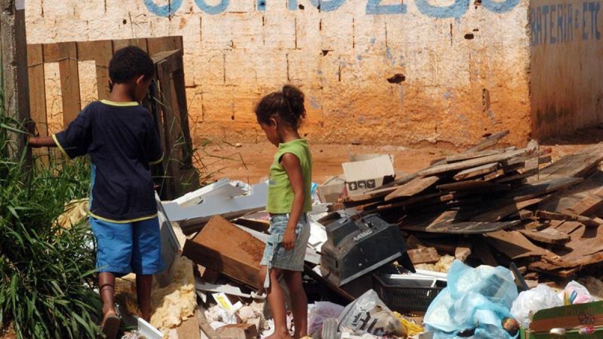Dos niños buscan entre la basura en Brasilia, Brasil.-EFE/Archivo