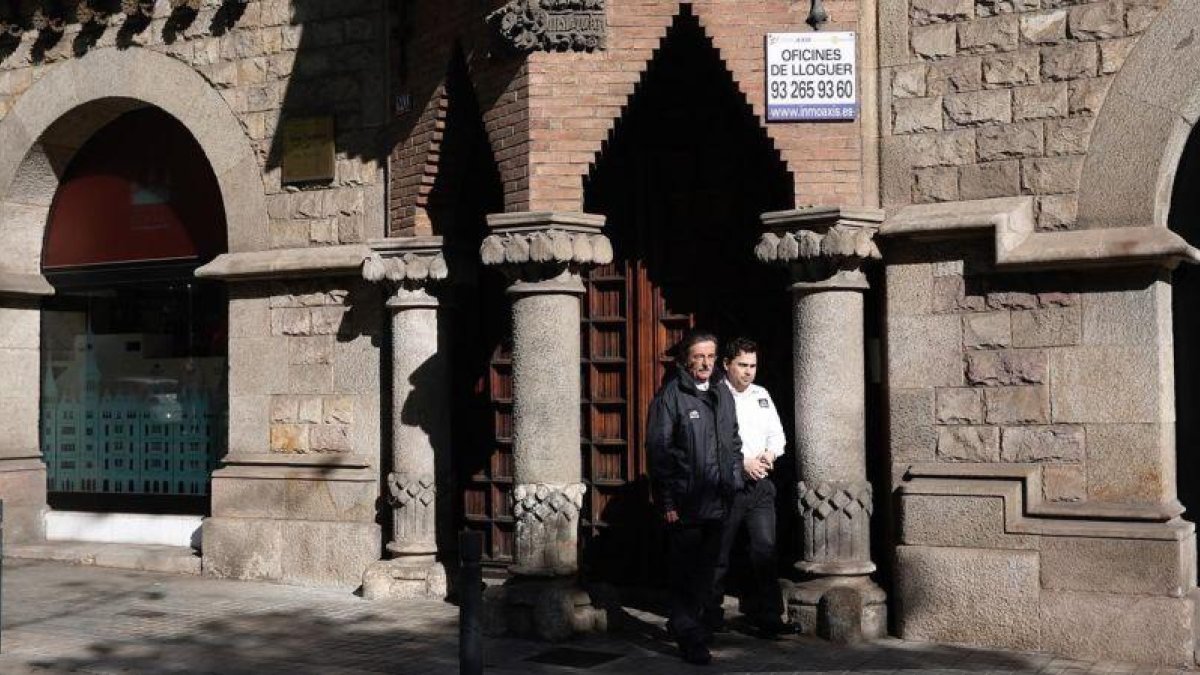 Un empleado de seguridad y el portero cierran las puertas de acceso a las oficinas del Diplocat, este jueves.-JOAN PUIG