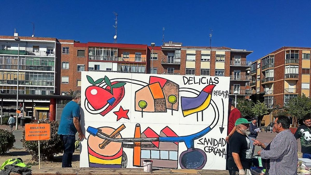 Mural reivindicativo con el mensaje ‘Delicias reclama sanidad cercana’, pintado ayer por Manuel Sierra y vecinos del barrio vallisoletano.-E.M.