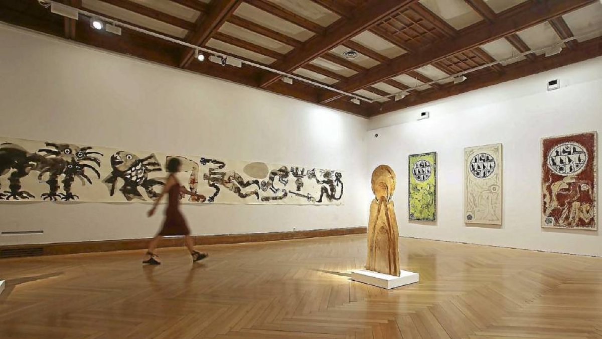 Una mujer pasa junto a las obras de Barthélémy Toguo, David Nash y Pierre Alechinsky en la sala superior del Museo de Pasión.-Miriam Chacón/Ical