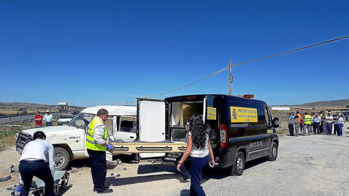 Trabajadores del Instituto Anatómico Forense, en la carretera nacional N-502 junto al todoterreno siniestrado.-A. GARCÍA