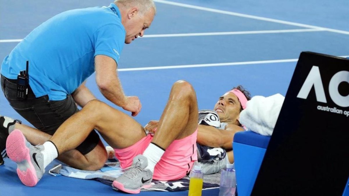 El osteópata atiende a Nadal antes de que el tenista tuviera que retirarse en el Open de Australia.-/ MARK CRISTINO