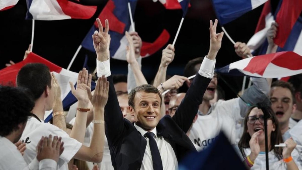 El candidato centrista Emmanuel Macron saluda al público durante un mitin en París, el 17 de abril.-EFE / YOAN VALAT