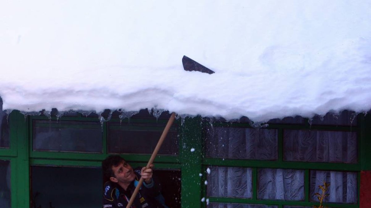 Un vecino de la localidad berciana de Colinas del Campo de Martín Moro Toledano (León), retira la nieve acumulada en su tejado durante los últimos días-Ical