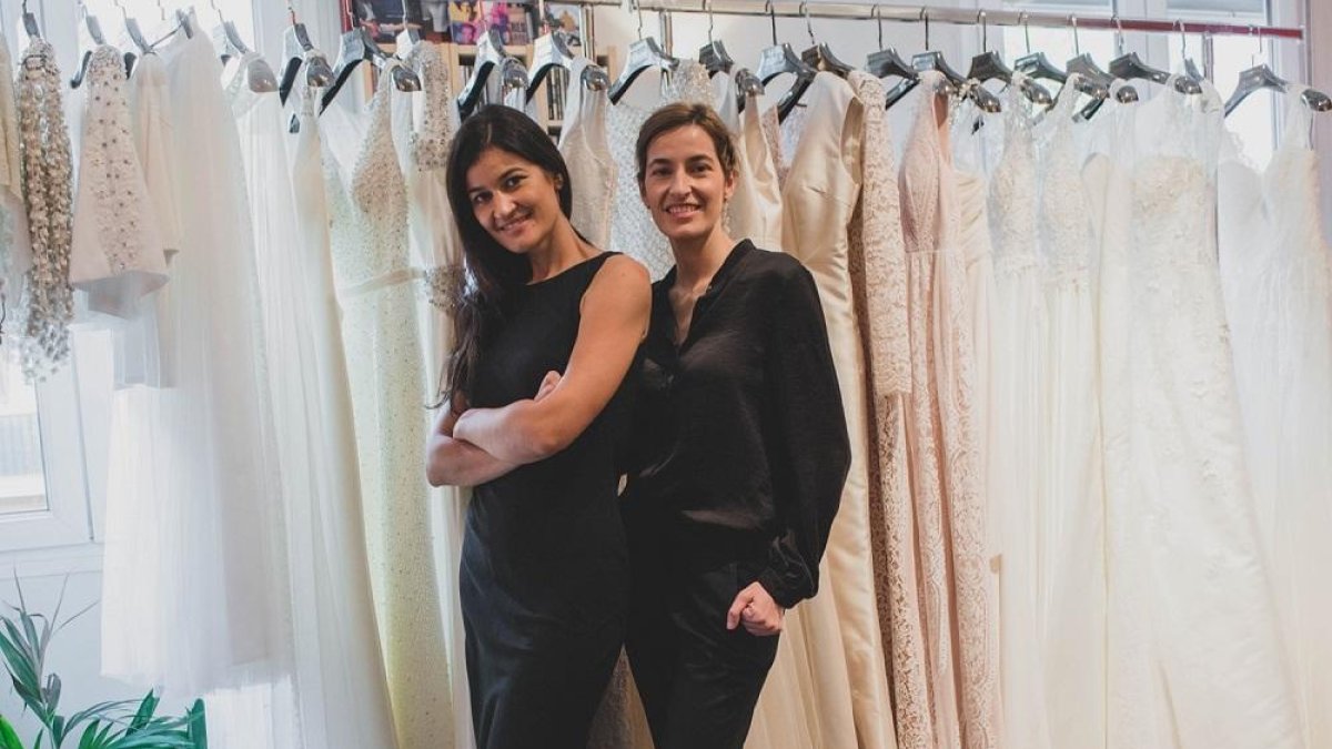 Beatriz y Cristina Lozano, fundadoras de Agapi-mu, posan con una selección de sus trajes de novia.-PORTRAITSINMADRID