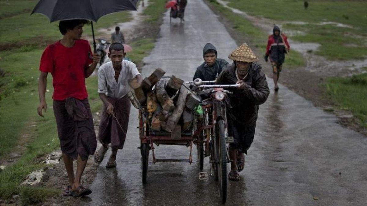 Una familia de rohingyas huye de las inundaciones en el 2014.-GEMUNU AMARASINGHE / AP