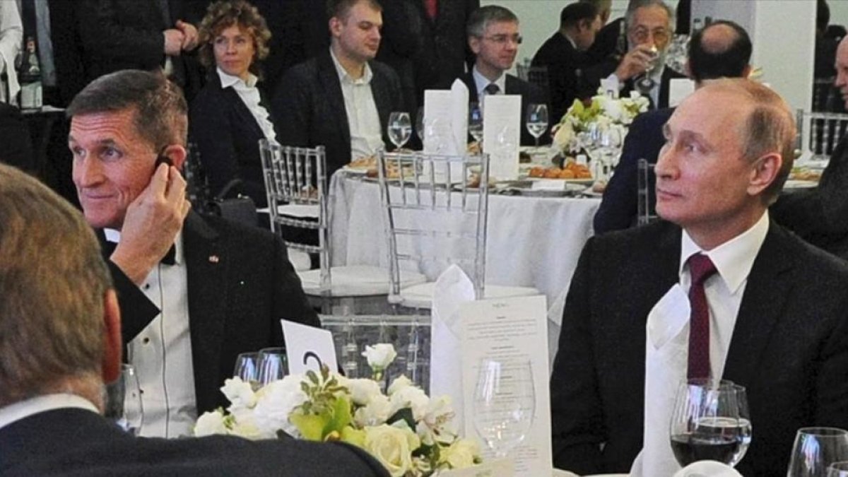 Foto tomada el 10 de diciembre de 2015 que muestra al presidente ruso Vladimir Putin sentado junto al entonces militar retirado estadounidense Michael Flynn en Moscú.-EFE / MICHAEL KLIMENTYEV