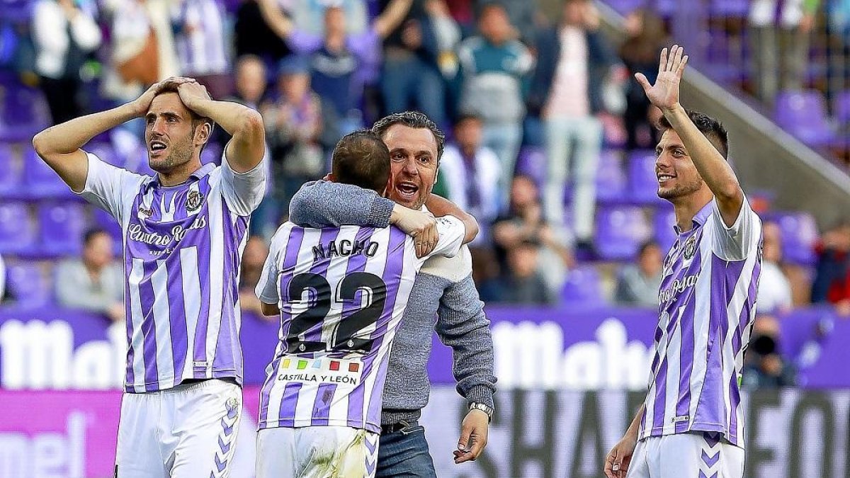 El entrenador Sergio se abraza a Nacho mientras Olivas (izquierda) y Plano saludan a la afición tras la victoria.-J.M. LOSTAU
