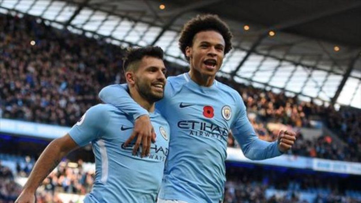Sané felicita al Kun Agüero después de que el argentino marcara de penalti al Arsenal.-AFP / OLI SCARF