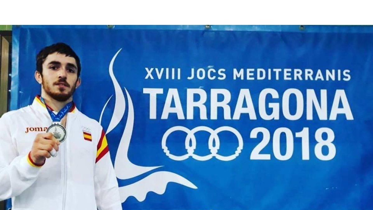 AlbertoGaitero posa con su medalla de plata sobre el mural con el logo de Tarragona 2018.-EL MUNDO