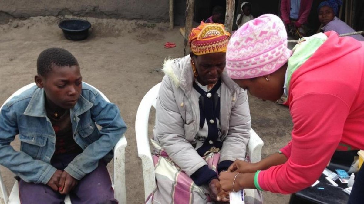 Gerlito (a la izquierda), el joven enfermo de malaria, mira como le hacen la prueba a su madre.-ANTONIO BAQUERO