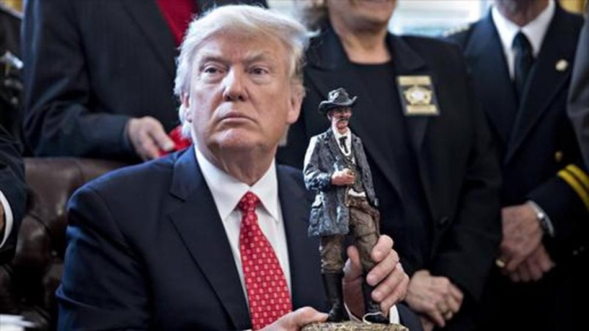 Trump sostiene una figura con la que fue obsequiado en la reunión que mantuvo ayer con los 'sheriffs' del país.-ANDREW HARRER
