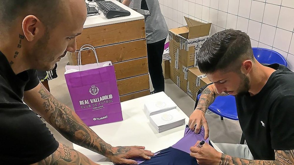 Antonio Domínguez firma la manga de la camiseta de un aficionado.-EL MUNDO