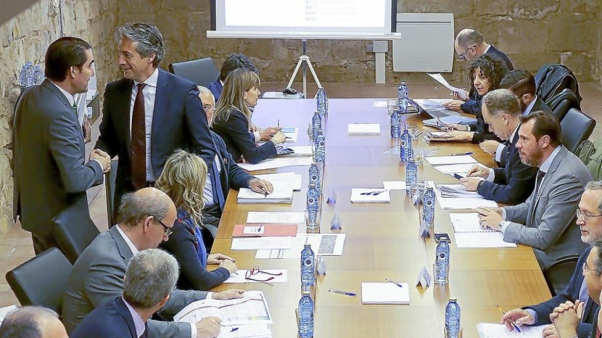 El consejero Juan Carlos Suárez-Quiñones saluda al ministro Íñigo de la Serna mientras al otro lado de la mesa el alcalde, Óscar Puente, observa la escena.-J.M. LOSTAU