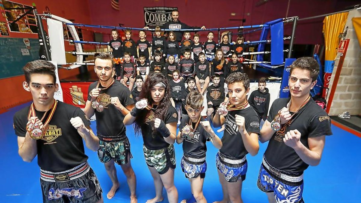 Los medallistas de laAcademia Combat posan con sus medallas ante la mirada de sus compañeros y de su entrenador, Alfonso Durán.-J. M. LOSTAU