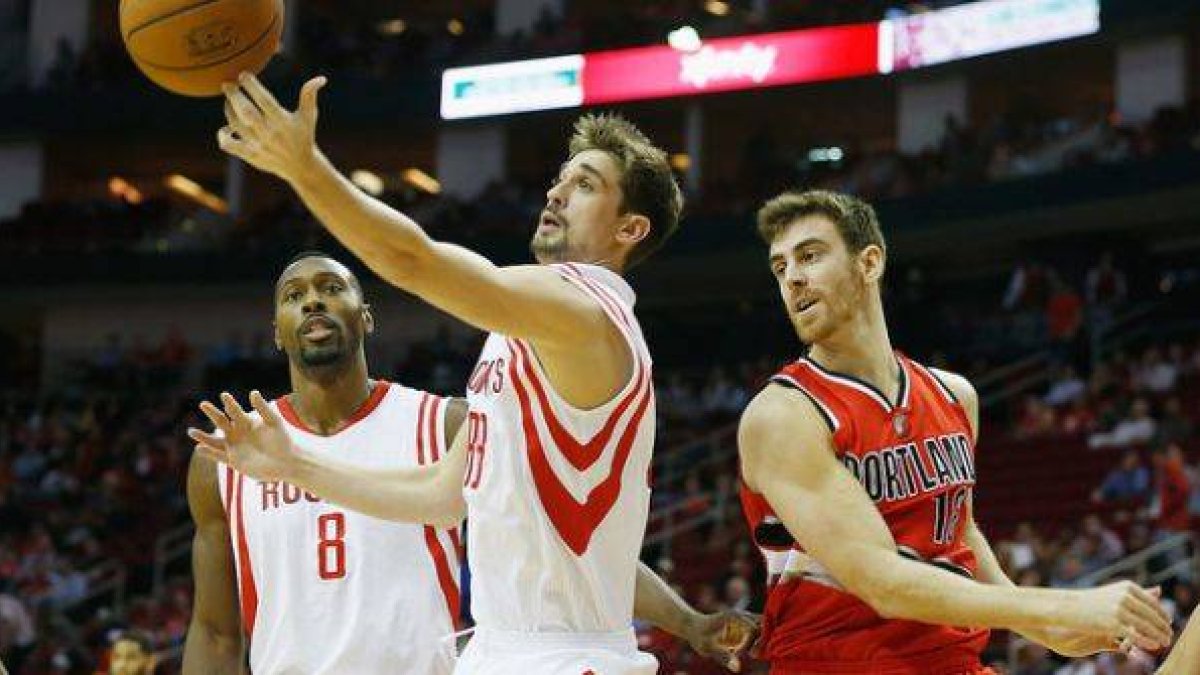 Víctor Claver (derecha) observa cómo Alexey Shved se hace con el balón, en el partido que han disputado los Trail Blazers y los Rockets.-Foto: AFP / SCOTT HALLERAN