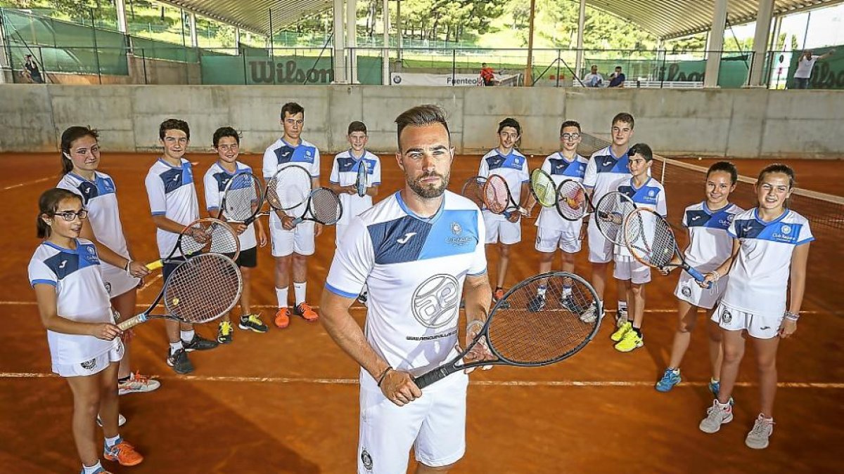 El tenista Alberto Esguevillas posa en primer plano junto a varios alumnos de su escuela en las pistas del Club La Raqueta.-M.Á. SANTOS