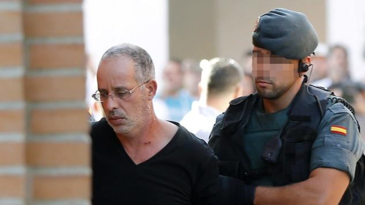 El presunto autor del asesinato de Eva Blanco, es trasladado por un agente de la Guardia Civil al juzgado de instrucción número 4 de Torrejón de Ardoz,.-EFE / CHEMA MOYA