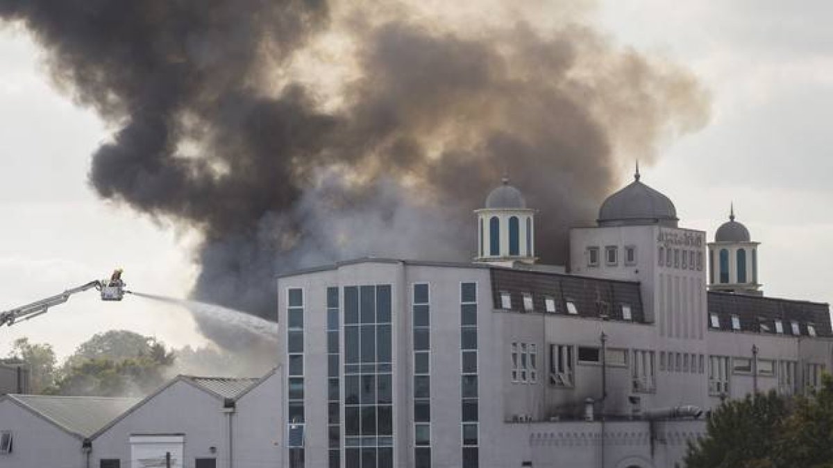 Los bomberos luchan contra el fuego y el humo en la mezquita de Baitul Futuh, este sábado.-AFP / JACK TAYLOR
