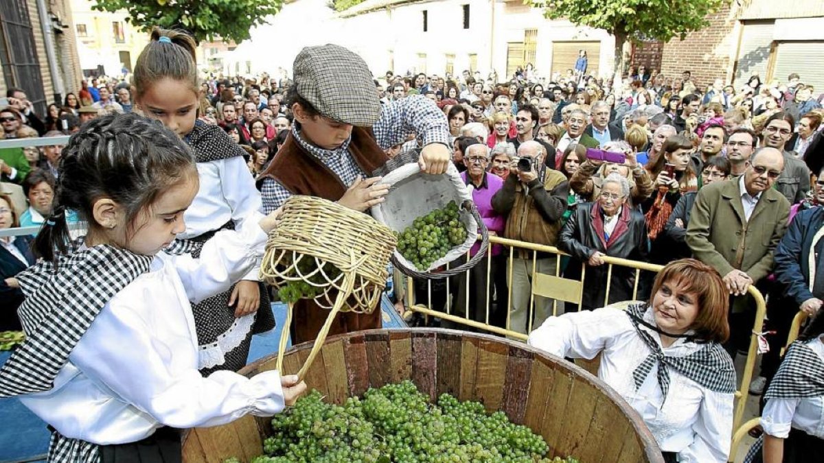 Tres niños arrojan uvas a un lagar en una anterior edición de la Fiesta de la Vendimia de Rueda.-J.M. LOSTAU