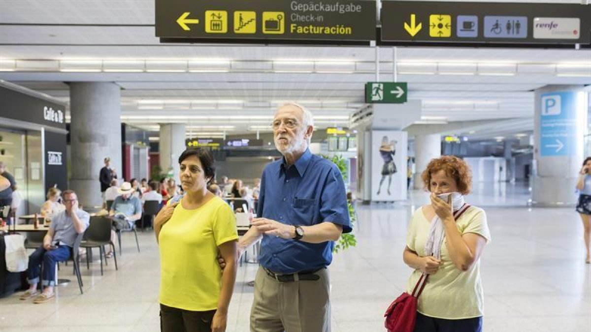 El director general de la Fundación Vicente Ferrer, Jordi Folgado Ferrer, junto a dos de las seis heridas del accidente en la India que se saldó con la muerte de cuatro personas, hoy a su llegada al aeropuerto de Málaga.-EFE / CARLOS DÍAZ