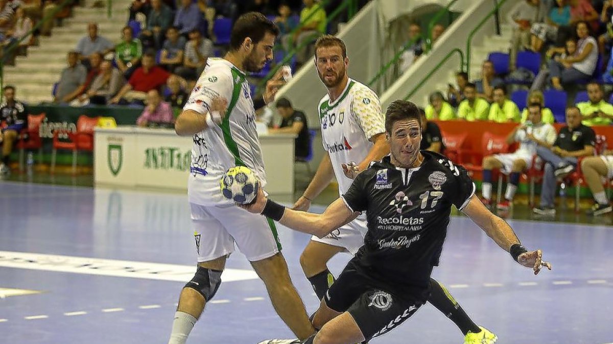 Abel Serdio, pivote del Atlético, se abre paso para tirar entre dos jugadores del Anaitasuna.-PHOTO-DEPORTE
