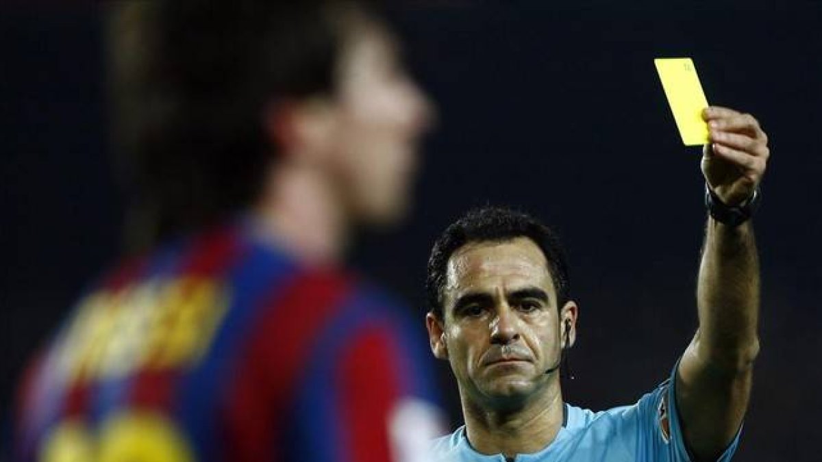 Velasco Carballo muestra una tarjeta amarilla a Messi.-Foto: REUTERS