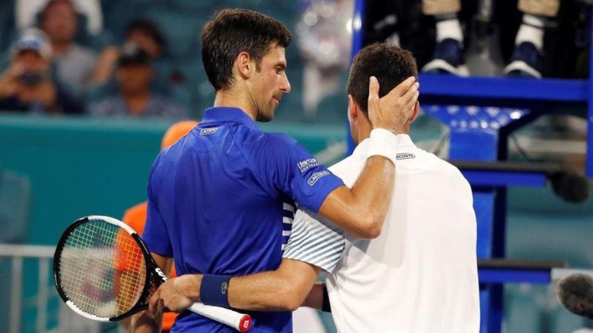 El saludo final en la gran victoria de Bautista Agut sobre Djokovic.-EL PERIÓDICO