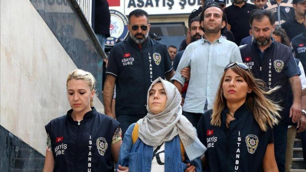 La policía escolta a una periodista detenida ante el juez en Estambul.-ALI AKSOYER