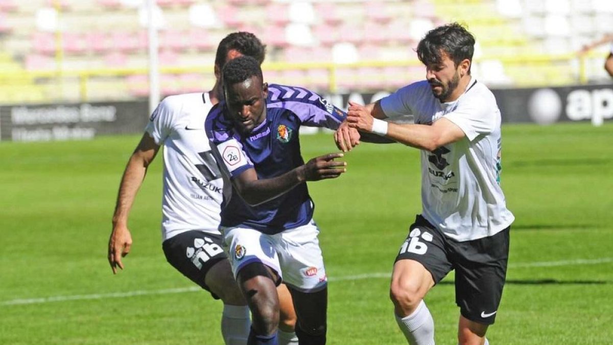 El Hacen intenta llevarse el balón ante la presencia de dos jugadores del Burgos.-ISRAEL L. MURILLO