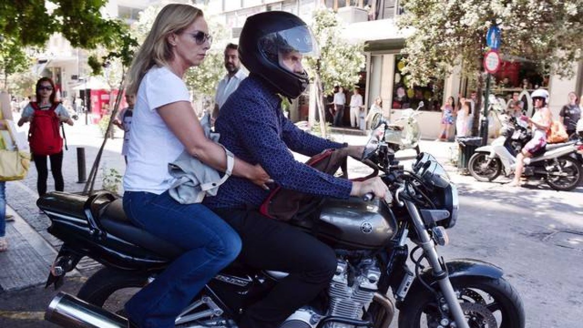 El ya exministro de Finanzas griego, Yanis Varoufakis, y su mujer, Danae Stratou, encima de una moto a la puerta de su casa, en Atenas.-Foto:   AFP / LOUISA GOULIAMAKI