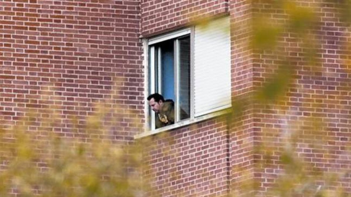Javier Limón, el marido de Teresa Romero, asomado a la ventana de su habitación del Carlos III.-
