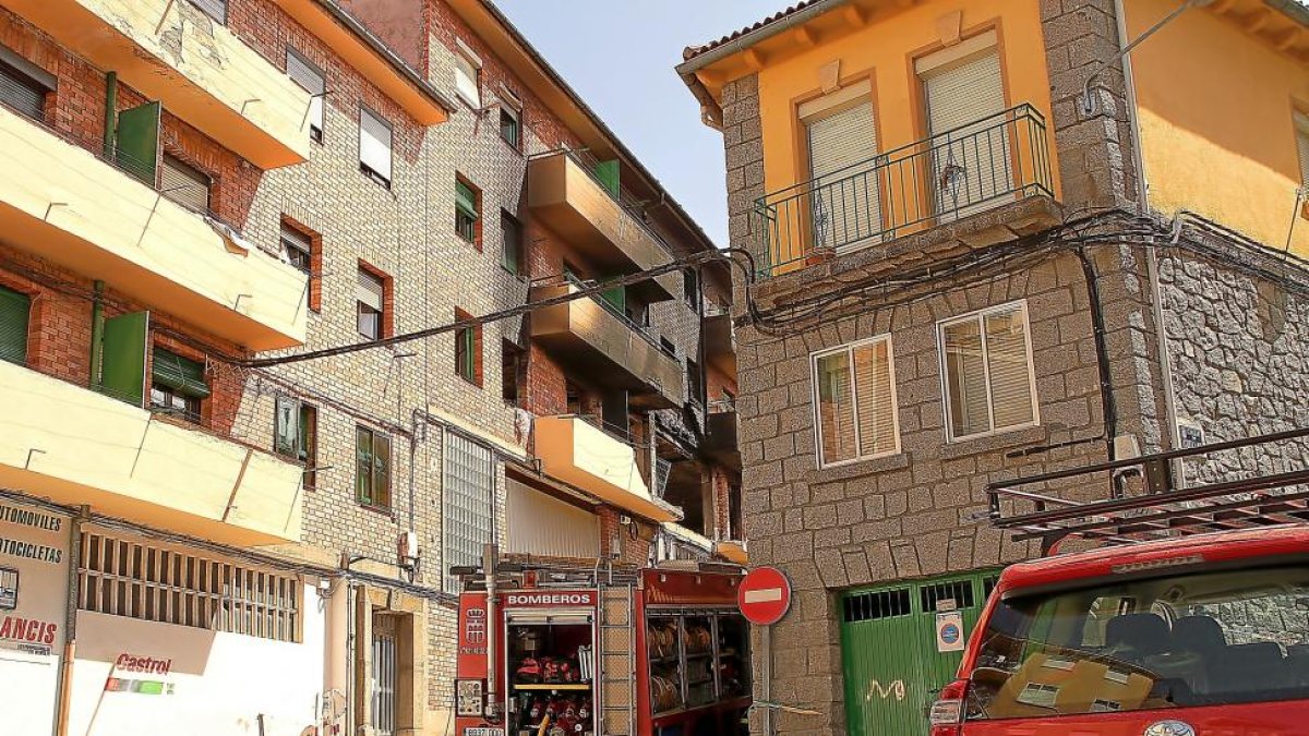 Los bomberos durante las labores de extinción en la zona del incendio que provocó la muerte de una mujer y siete heridos ayer en Segovia.-ICAL