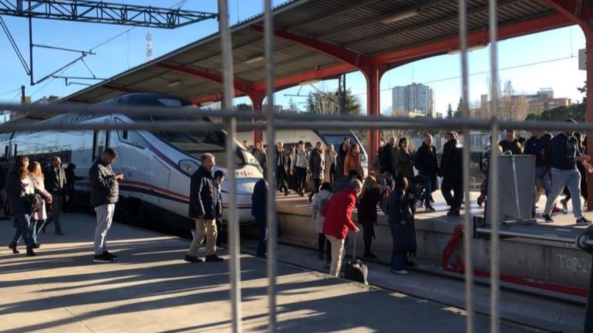 Pasajeros de Renfe cruzando las vías de Chamartín al bajarse del tren.- E. M.