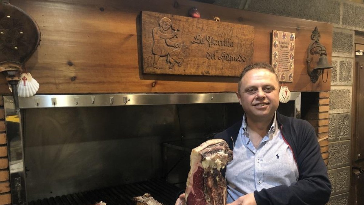 Fernando, en su restaurante, junto a una de sus afamadas piezas de carne rojas de buey, su especialidad-