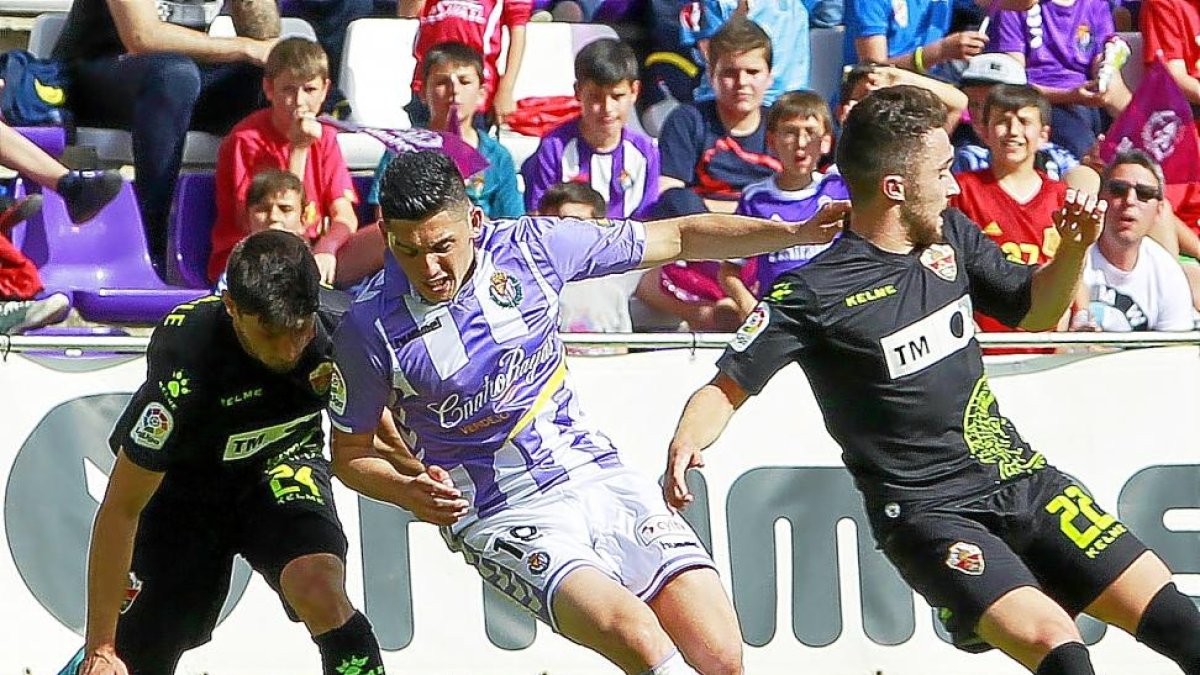 Espinoza trata de regatear a dos jugadores del Elche.-J.M.LOSTAU