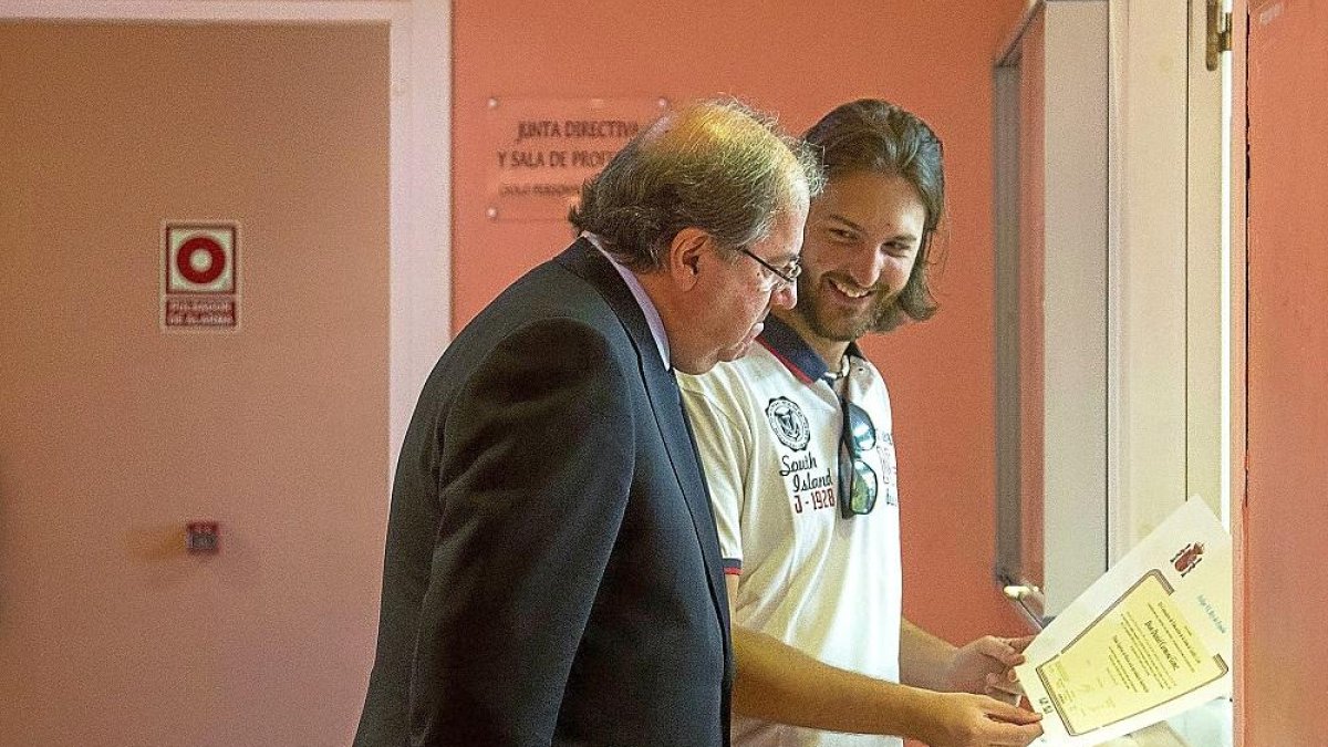 Herrera observa el título de un joven, antes de inaugurar el curso.-ICAL